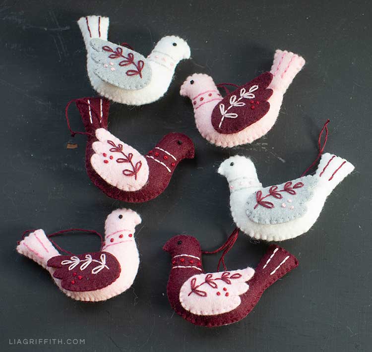 pink, red, and white handmade bird ornaments with embroidery