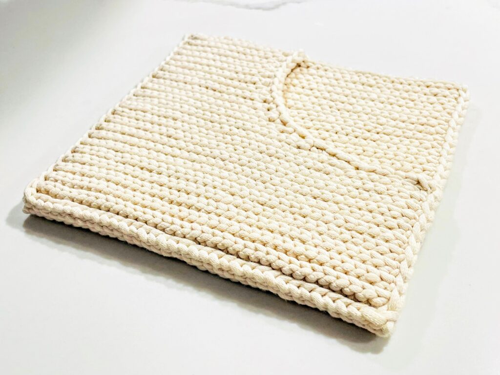 white handmade crochet potholder with a pocket