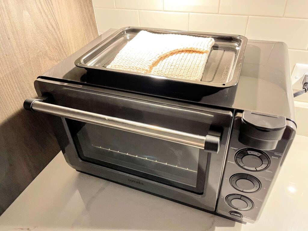 white crochet potholder on top of a toaster oven